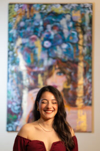 Ritratto di giovane cantante donna sorridente con capelli ricci, sfondo con colori vivaci