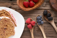 Ciotola in legno con lamponi e more fresche su superficie rustica, fotografia food styling