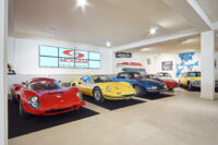 Garage showroom, museo mogam, con auto sportive di lusso rosse e gialle esposte su pavimento lucido