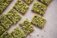 Croccanti al pistacchio artigianali ricoperti di granella di pistacchio verde su superficie di marmo